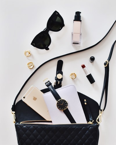 女式太阳镜和黑色包，带手表和iPhone6